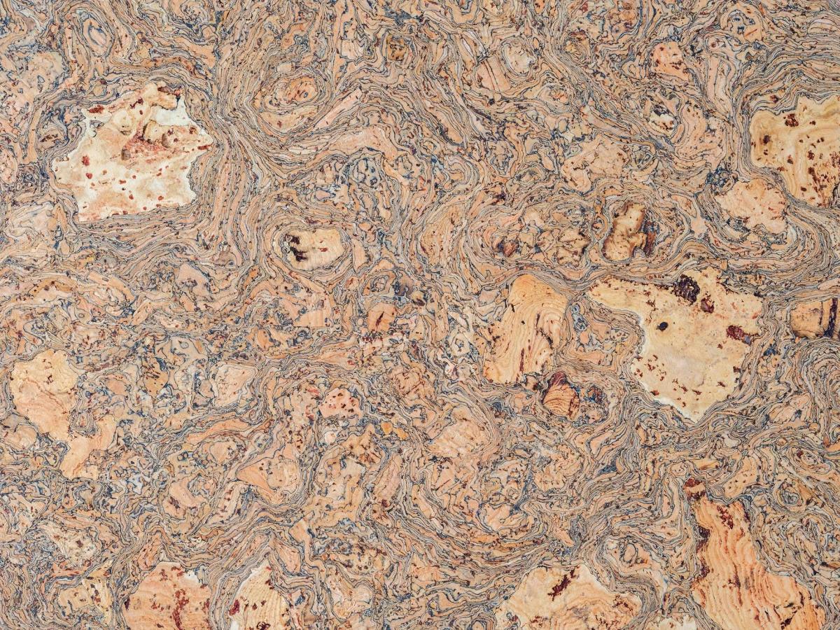 A very close view of cork, its surface a dense mottled pattern of pale tan cells and darker grey veining.