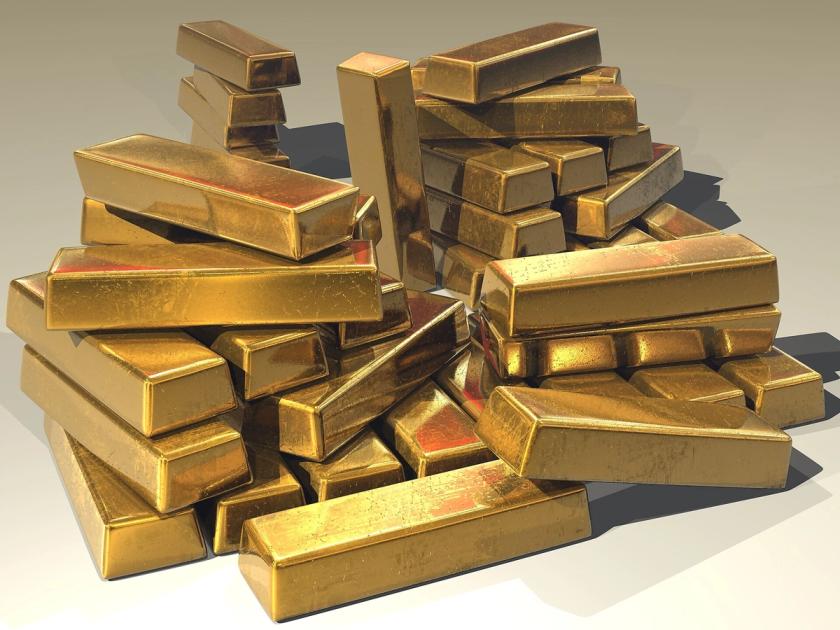 Stacked gold bullion bars, the publicly priced material whose value is printed continuously by the bullion markets.