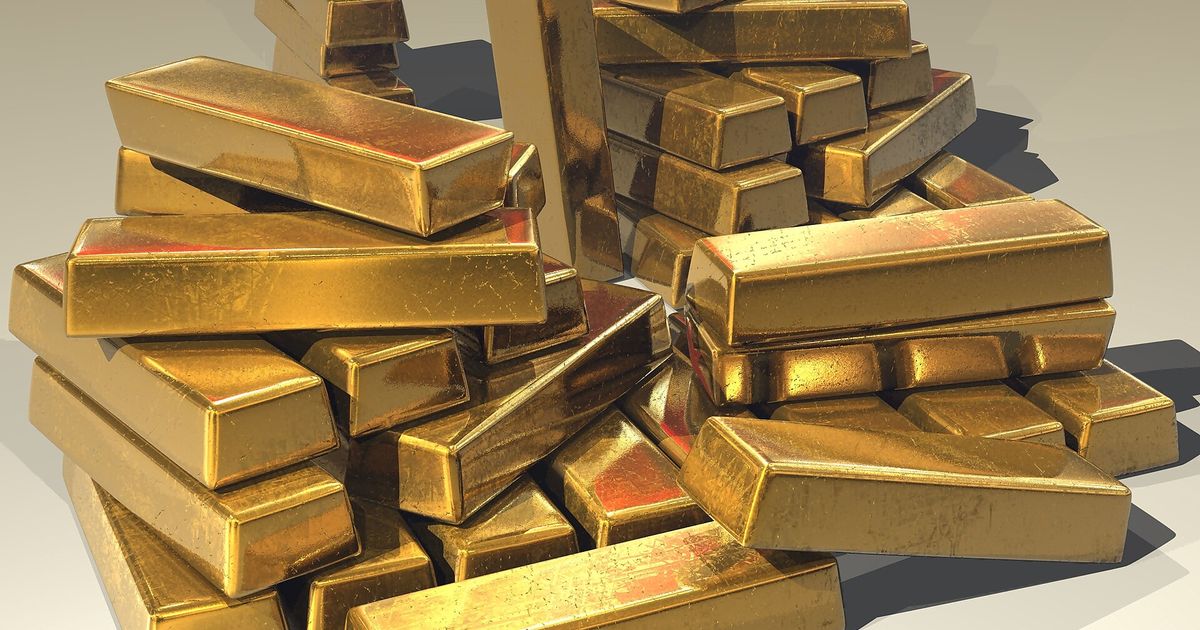 Stacked gold bullion bars, the publicly priced material whose value is printed continuously by the bullion markets.
