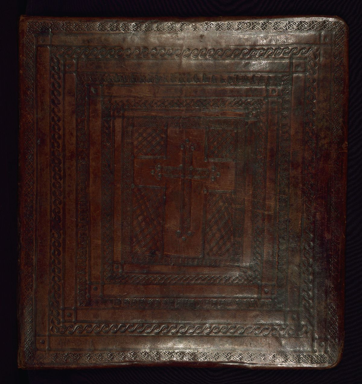 The decorated outer board of an Ethiopian manuscript, tooled leather over wooden boards with a cross design.