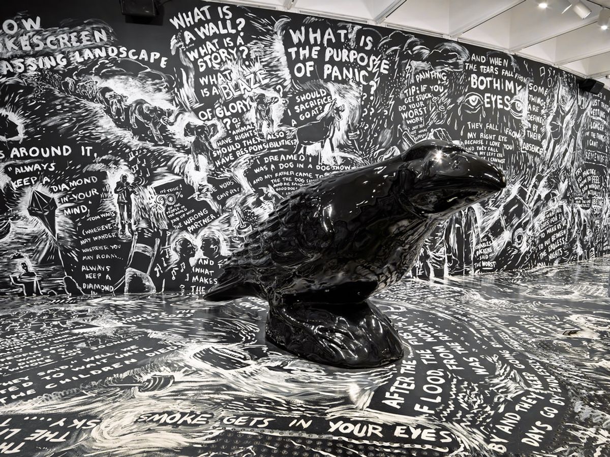 Glossy crow sculpture in a text-filled immersive art installation at the Hirshhorn Museum in Washington D.C., representing the experience economy's convergence of art environment and visitor participation.