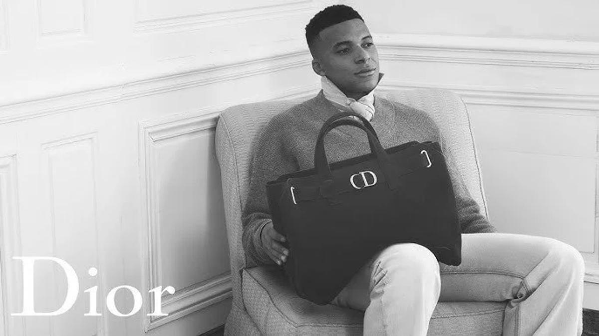 The athlete as a Hollowed Object: In Jonathan Anderson’s debut Dior SS26 campaign, Kylian Mbappé cradles a bag coded in traditional saddle-making geometry; the raw physical labor of sport completely evacuated to leave a pristine, marketable signature shell.