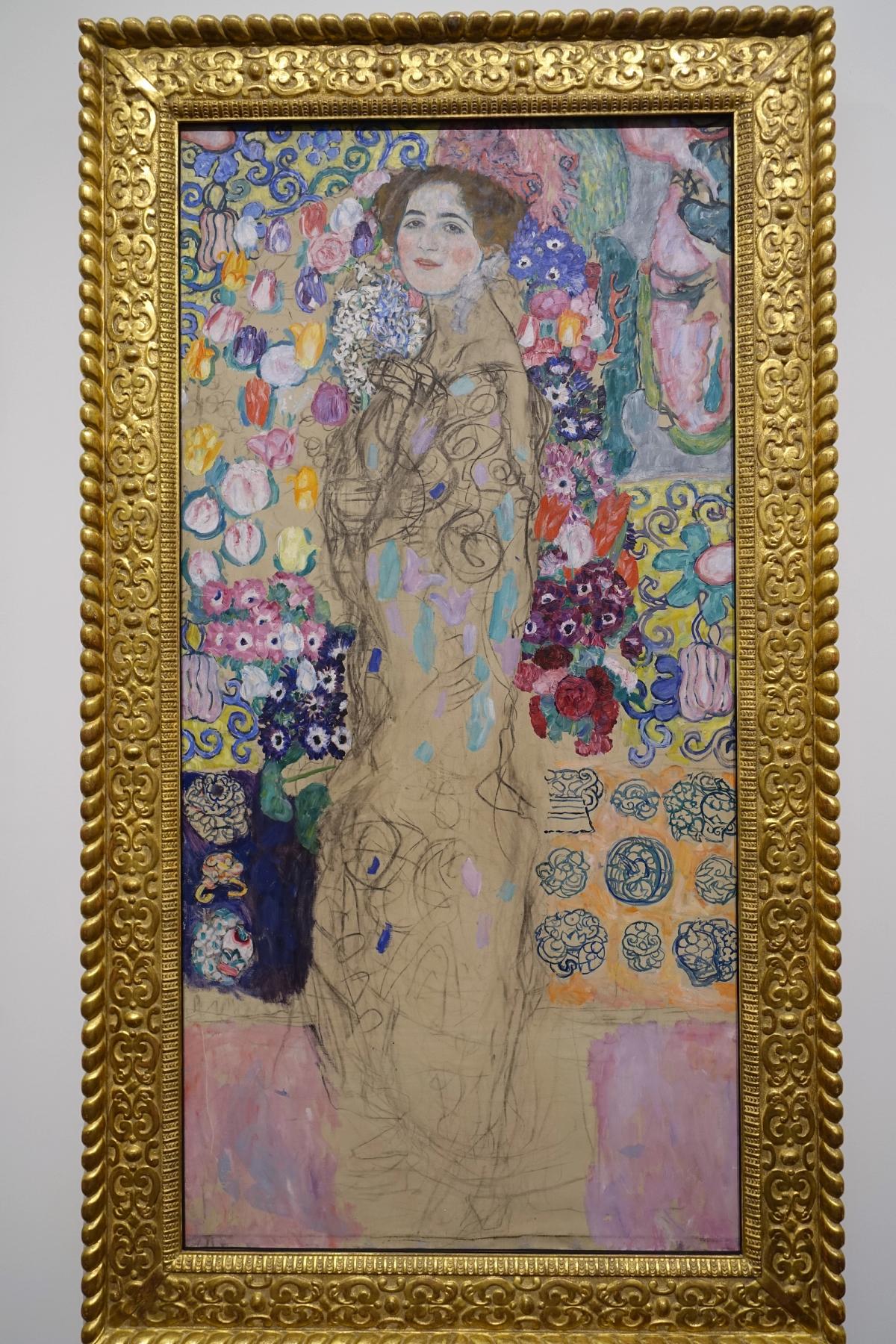 An unfinished portrait of a young woman in a patterned robe, the lower part of the canvas left bare.
