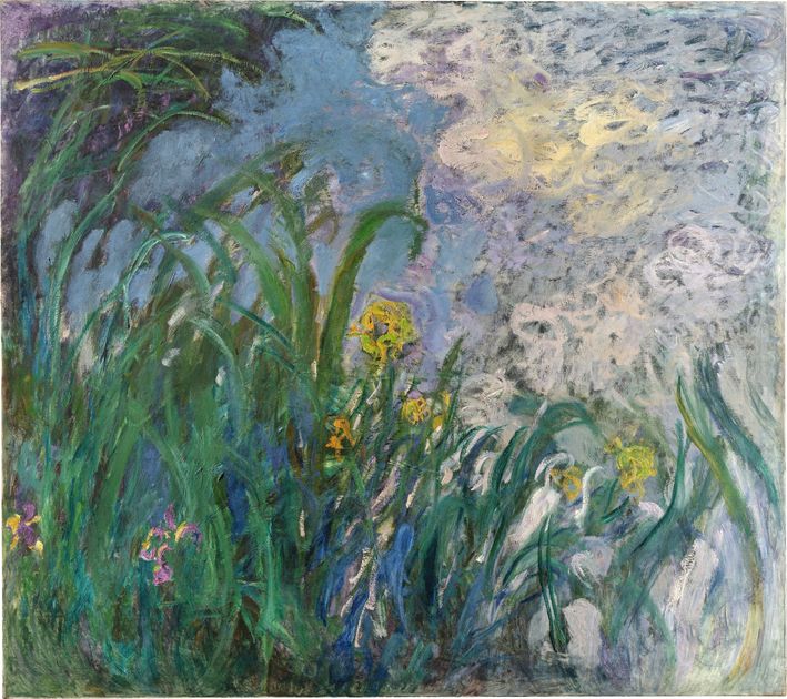 A large late Monet of irises at a water margin, green blades against blue violet water with yellow and white blooms.