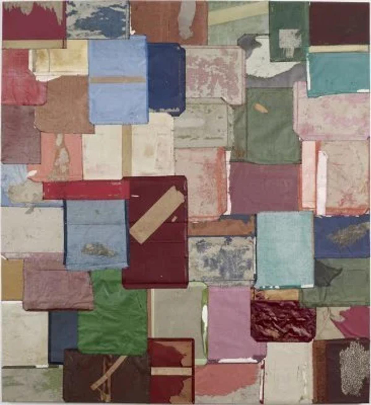 A large wall panel assembled from many salvaged book covers in faded red, green, blue and cream, laid edge to edge in a rough grid.
