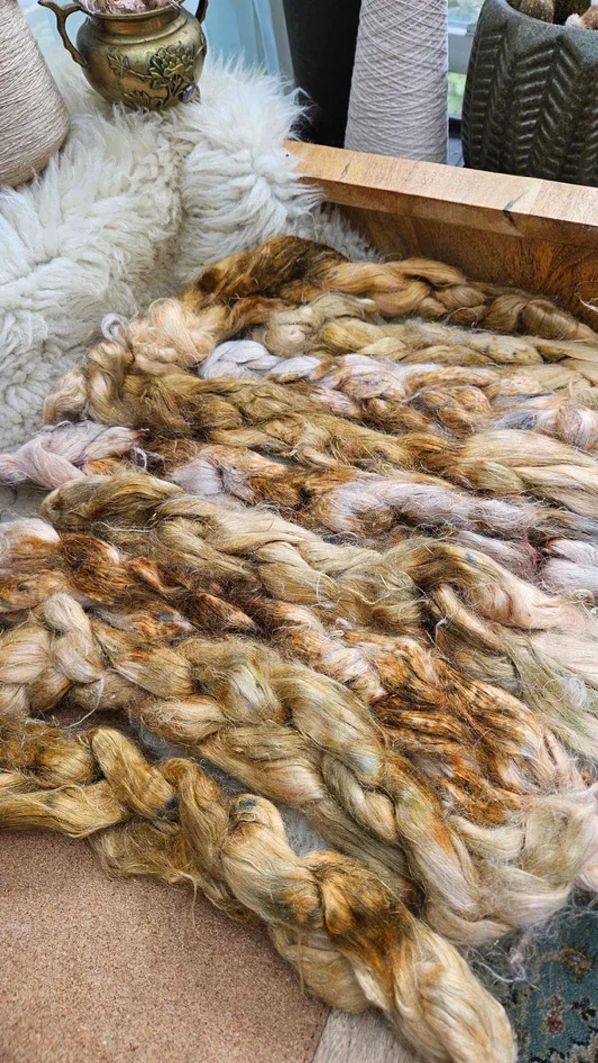 The visual ledger of Tactical Friction: Braided strands of raw, hand-processed flax fiber arrayed by tone, detailing the intensive physical interaction required before spinning can begin.