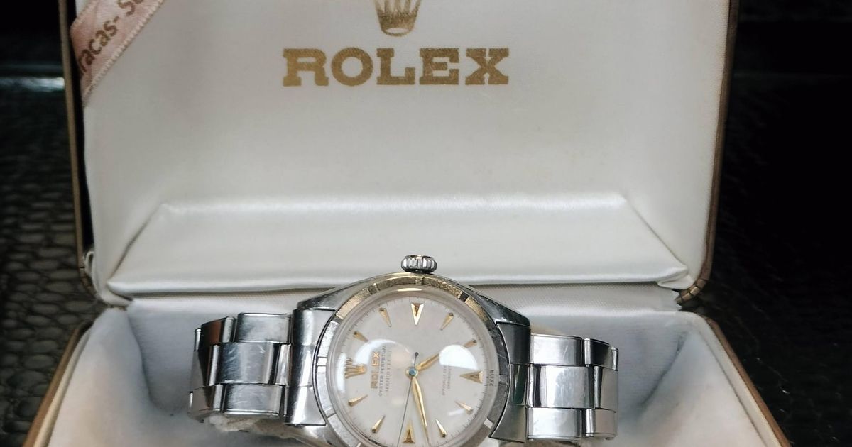 A steel Rolex Oyster Perpetual lying in its original green and cream presentation box, the lid gilt-stamped with the Rolex crown, a printed ribbon across it reading Caracas, Serpico y Laino.