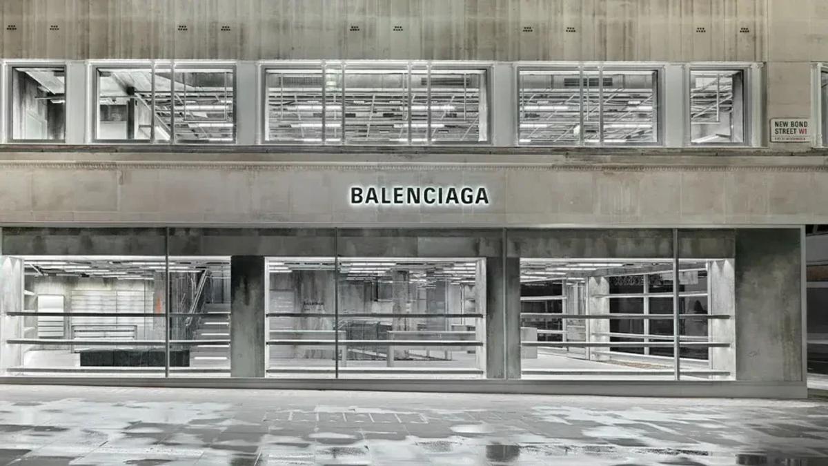 A black and white photograph of a modernist shopfront with continuous glazing and Balenciaga lettering above the windows.