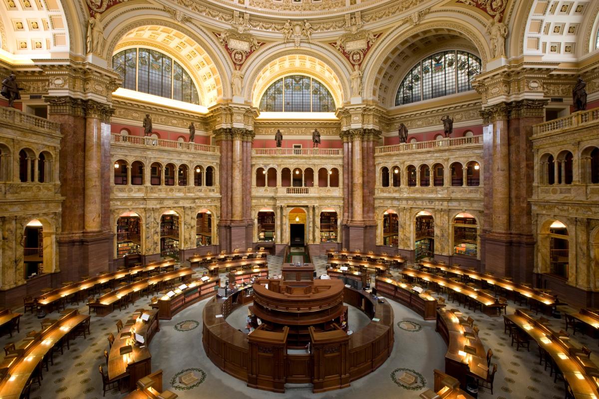The main reading room of the Library of Congress, its desks radiating beneath a domed ceiling.