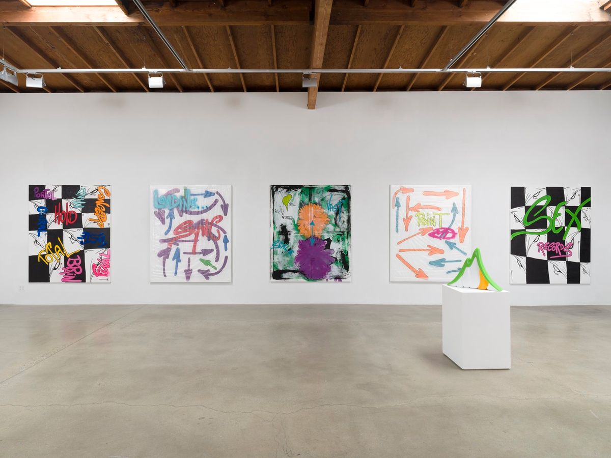 A gallery wall under an exposed wood-beam ceiling hung with five large paintings, a white plinth standing to the right.