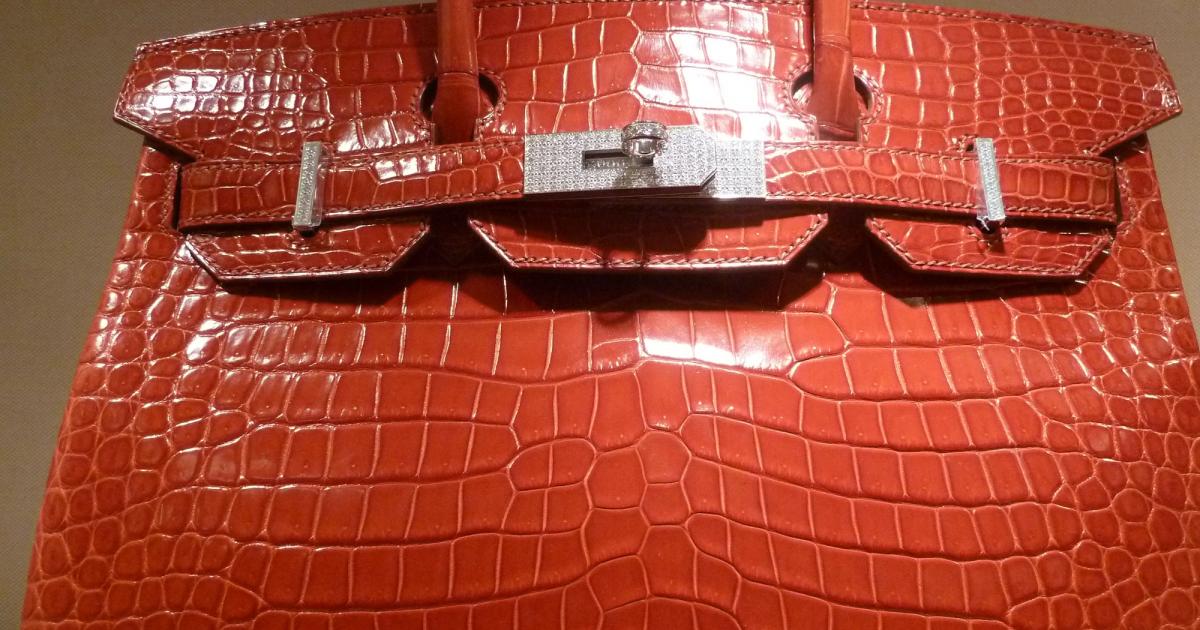 A crocodile-skin handbag photographed against a plain background.