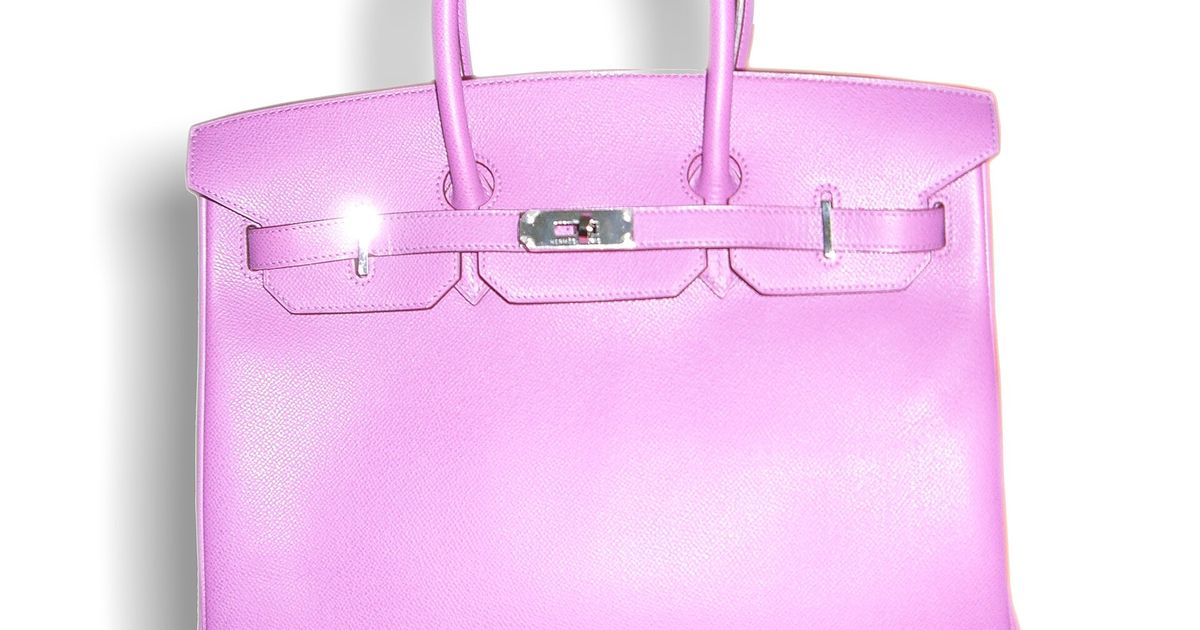 A pink leather Hermes Birkin bag photographed against a plain white background, its rolled handles upright and the lock and straps closed across the front.