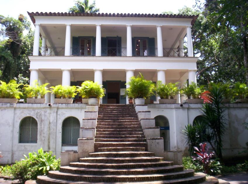 A nineteenth-century neoclassical house with a columned portico on a wooded hillside campus in Rio de Janeiro.