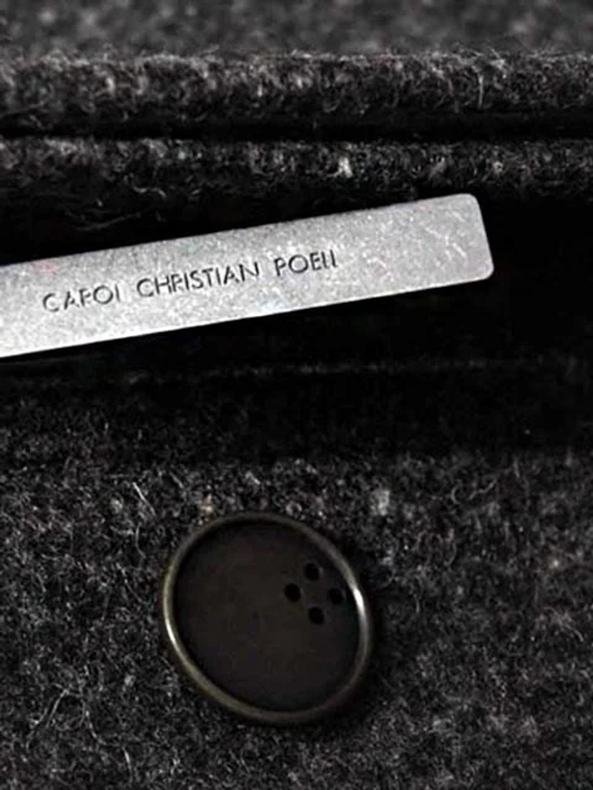  Narrative Control Through Absence: A detail shot of a CCP label and unique button, representing the brand's strategic detachment from the mainstream luxury market and its focus on intrinsic material worth. 
