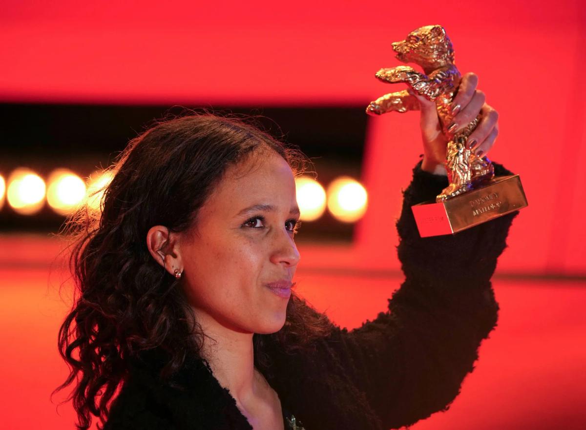 The intellectual weight behind the camera: Mati Diop celebrating her Golden Bear win for Dahomey, a documentary interrogating the contested custody and repatriation of royal treasures, bringing a hyper-critical, restorative gaze to Hermès's object system.