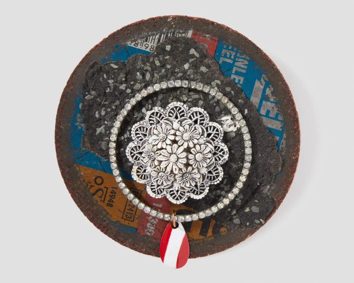 Robert Ebendorf, Cutting Disc Brooch Media: Metal cutting disc, plastic daisies, rhinestones, red and white tag. Dimensions: 385×385×1 in. (9.2×9.2×2.5 cm). An exemplary piece of Post-Luxury Conceptual Functional Art, this brooch showcases Ebendorf's aesthetic of juxtaposition by transforming an industrial cutting disc and discarded rhinestones into a philosophical object, forcing a re-evaluation of perceived material value.