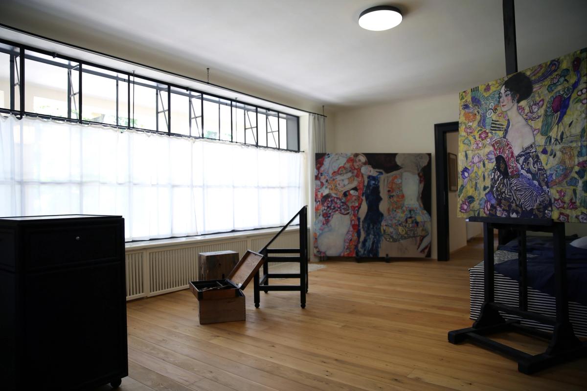 A reconstructed painter's studio with easel, canvases and tall windows.