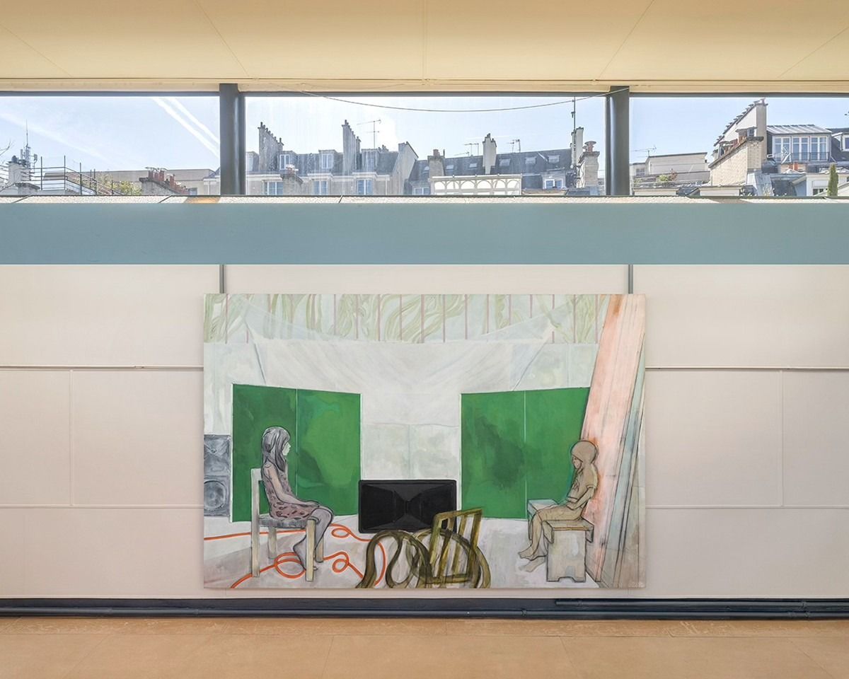 A large painting of two girls seated facing each other in a studio with green panels behind them, hung beneath a long horizontal window at the Maison La Roche, Paris rooftops visible above.