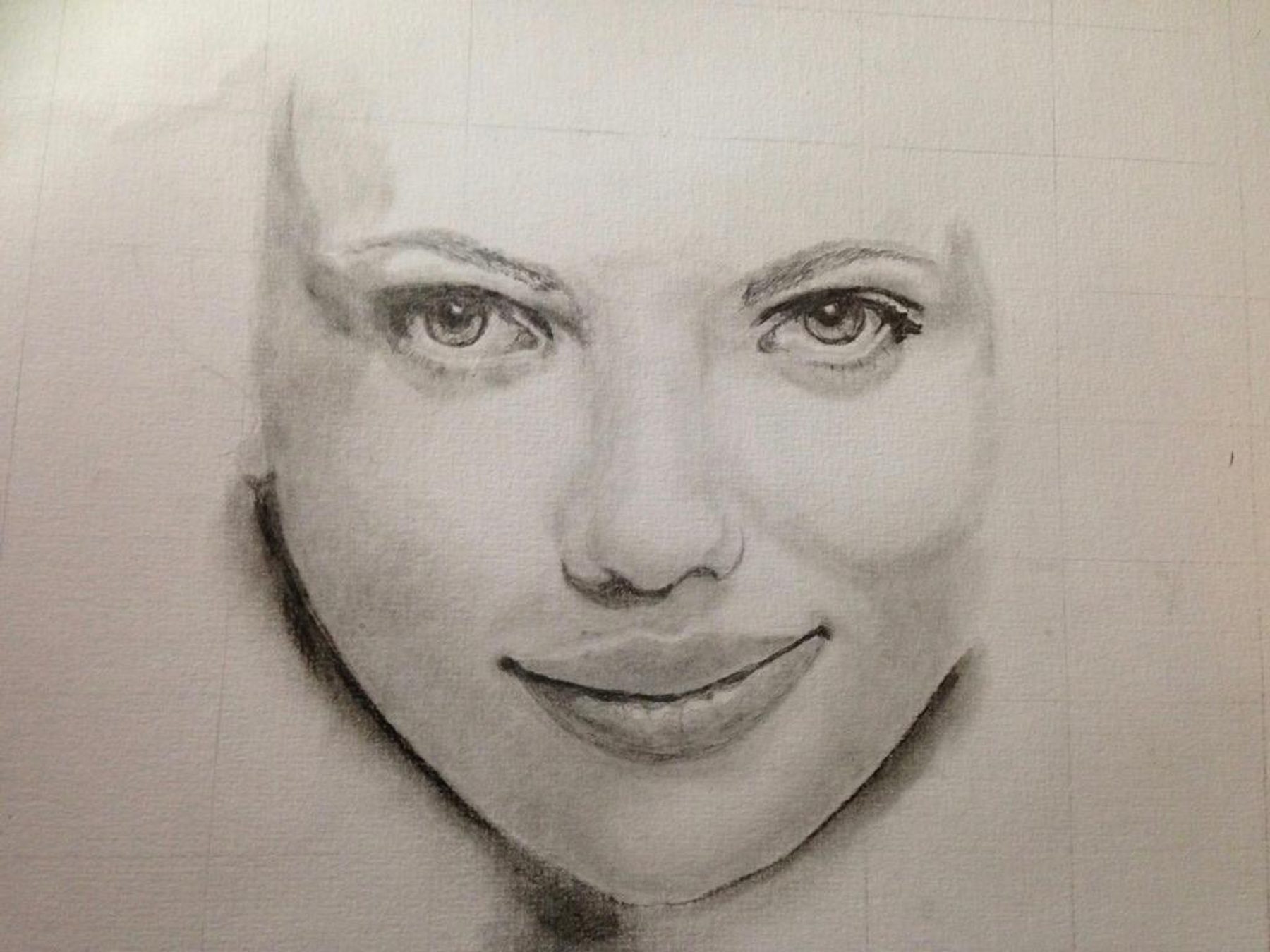 A graphite portrait study showing a woman’s eyes, nose, and mouth emerging from a lightly sketched face on white paper.