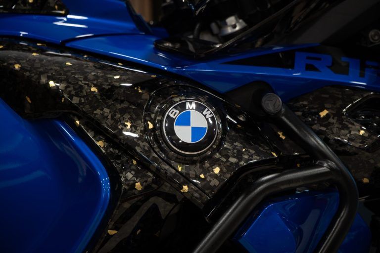 Forged carbon met bladgoud op een kuipdeel, rond het BMW-logo