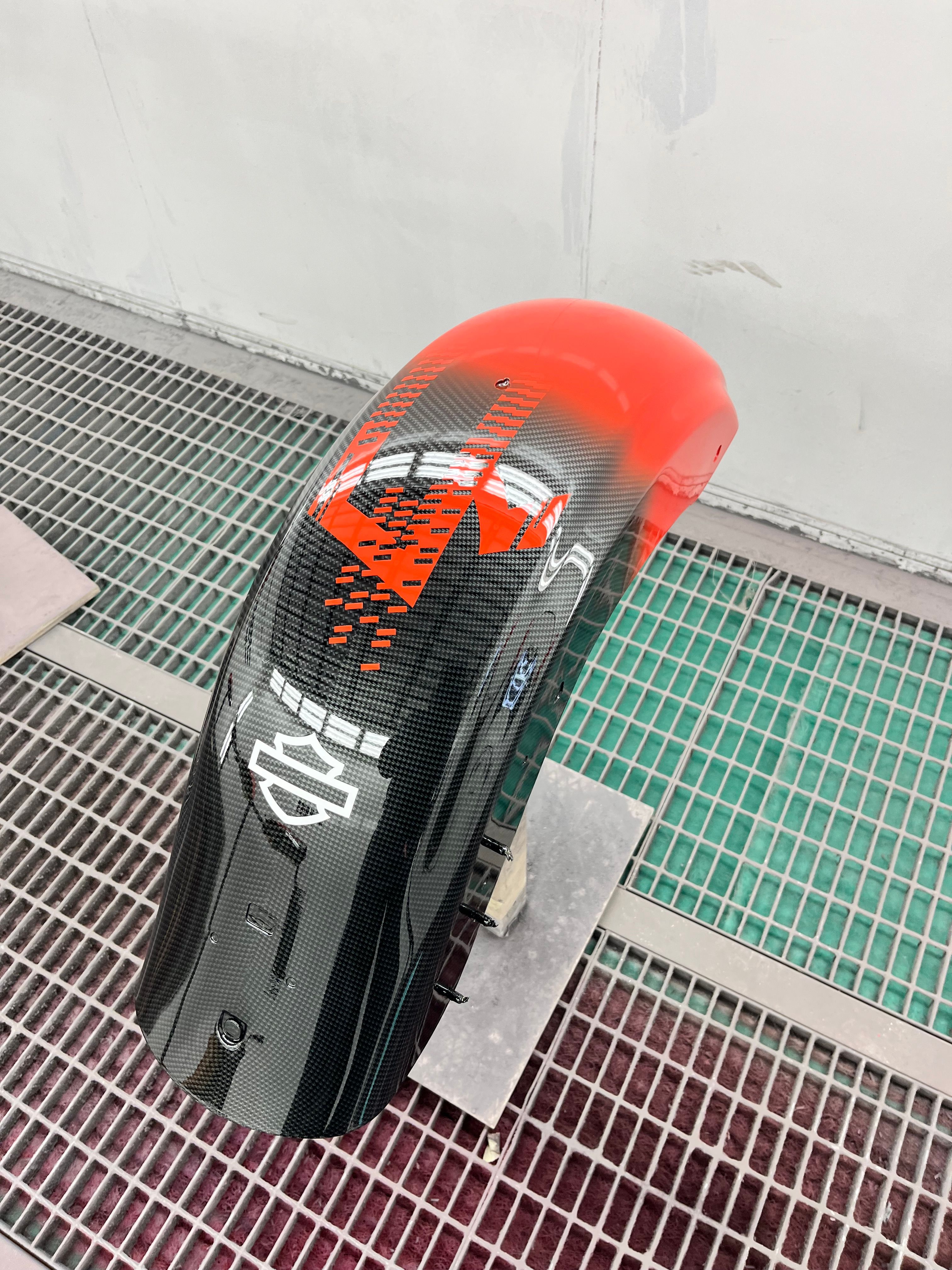 Achterspatbord in carbon met oranjerood blokpatroon
