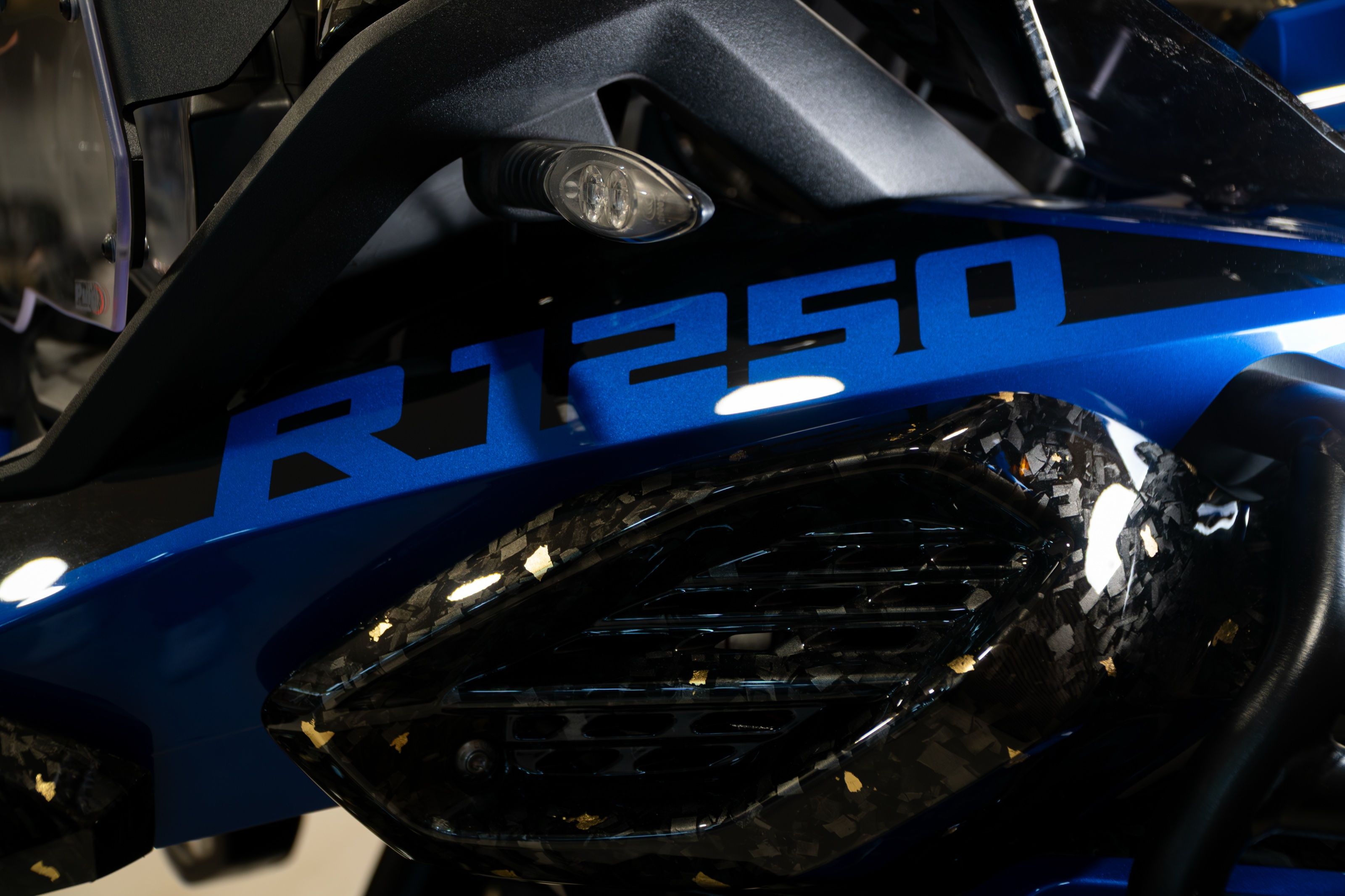 R1250-logo boven een luchtinlaat in forged carbon