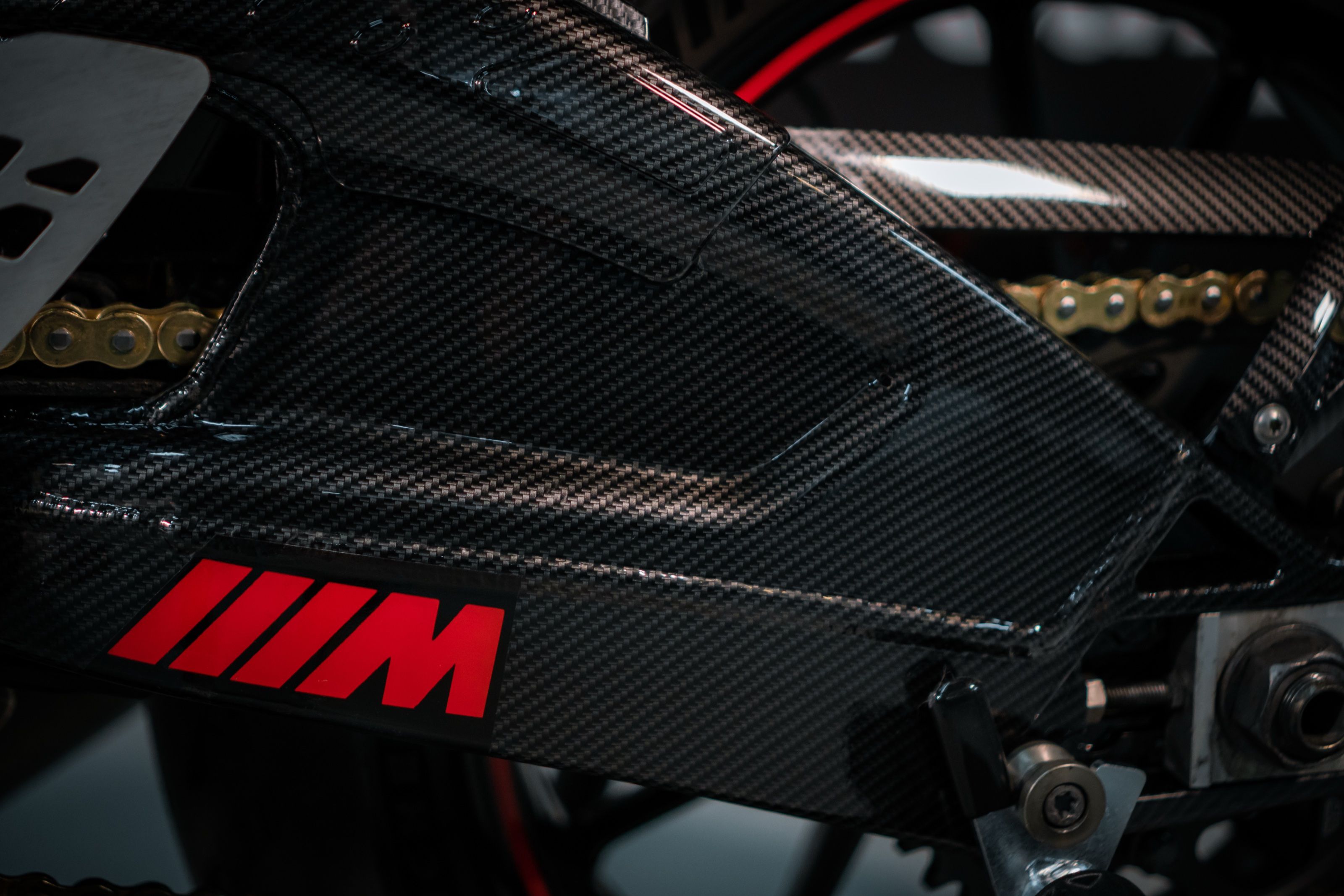 Rood ///M-logo op de carbon swingarm