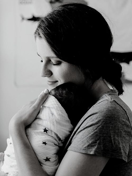 black and white photo of a young mother cradling an infant | Self-mothering for teachers and health professionals | Tempo therapy and consulting