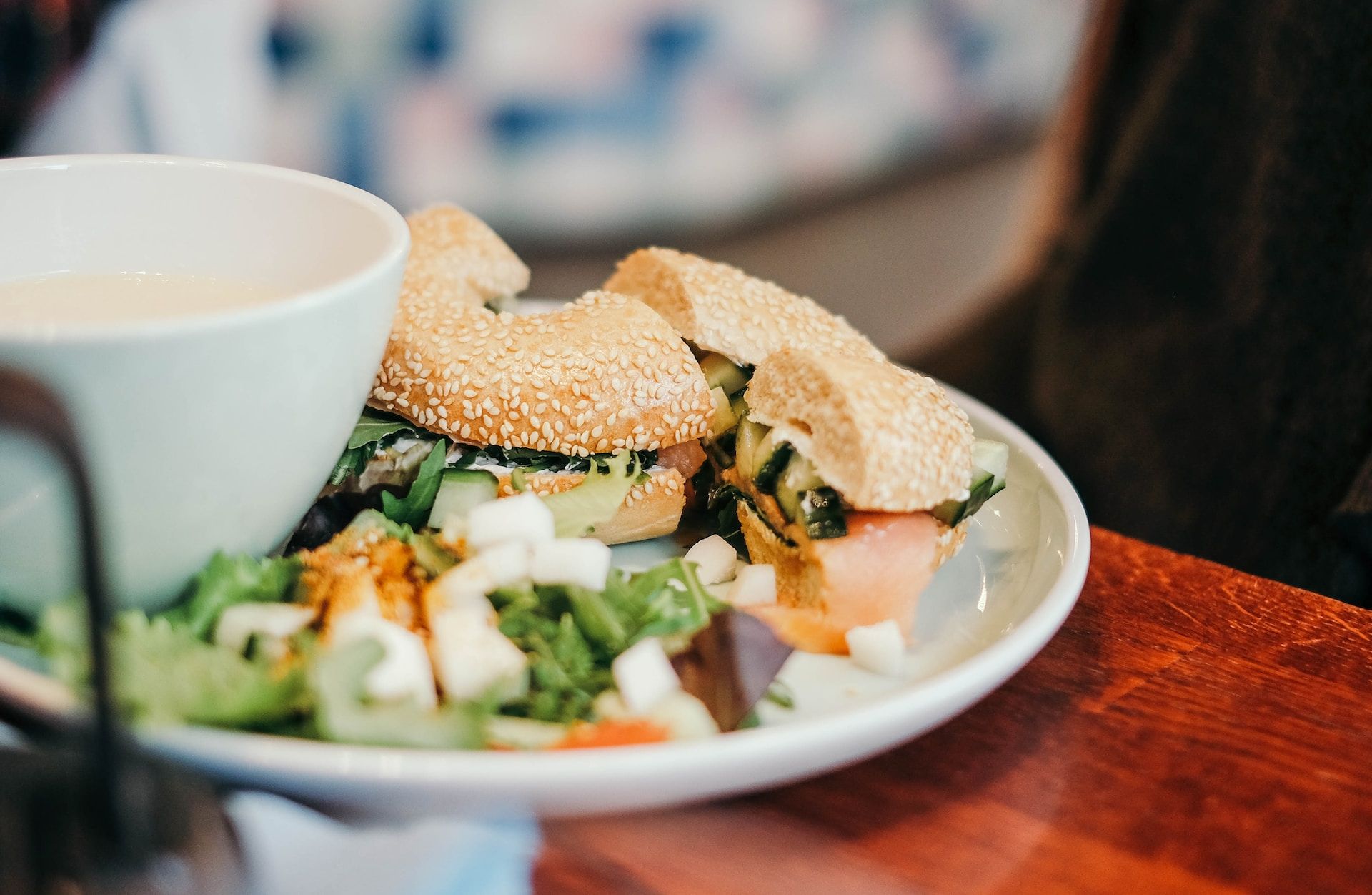 a salad bagel sits on a white plate in the foreground | healthcare workers mental health week | Tempo Therapy and Consulting