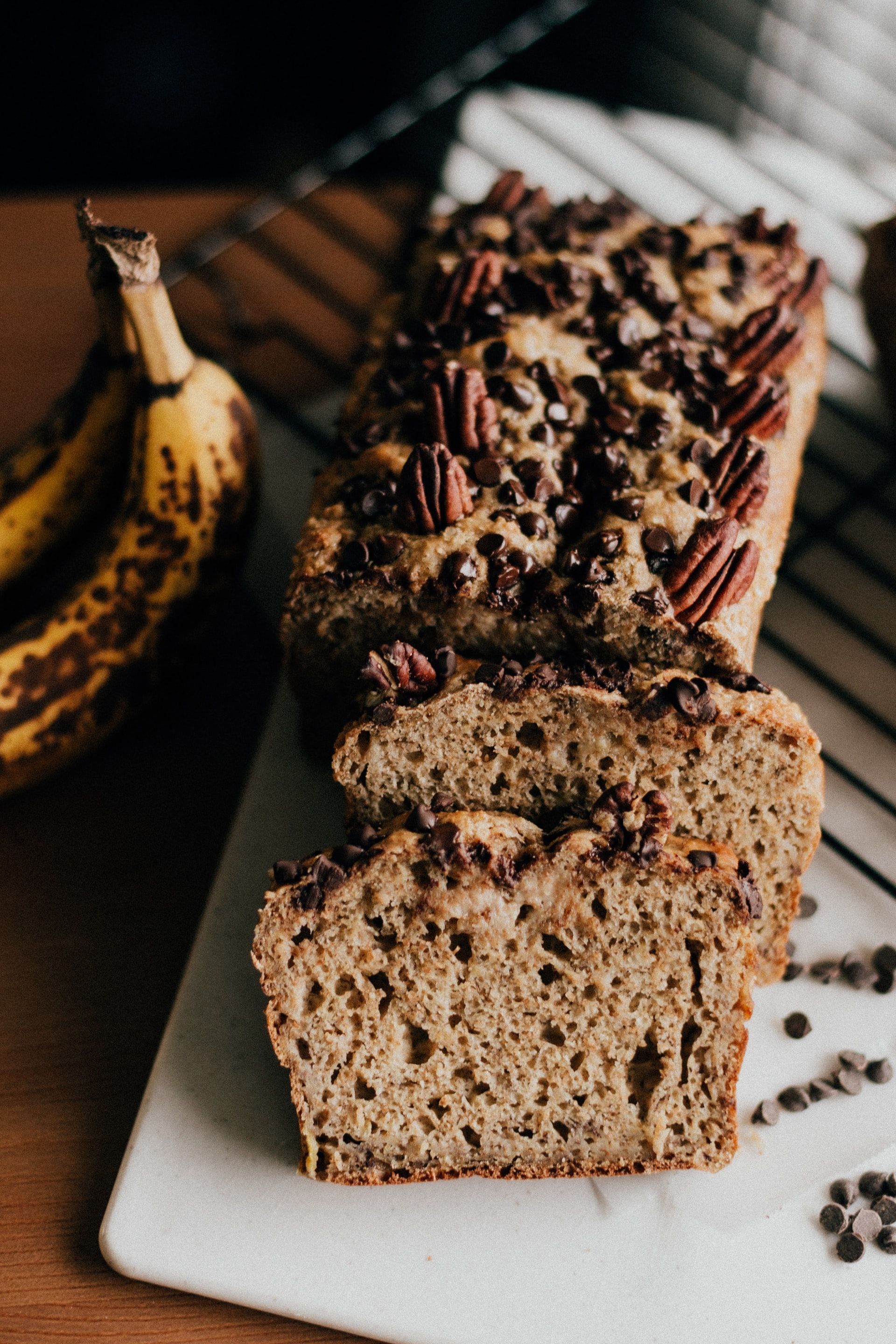 freshly baked banana loaf with nuts and chocolate chips on a board next to an old banana | risking connection | Tempo Therapy and Consulting