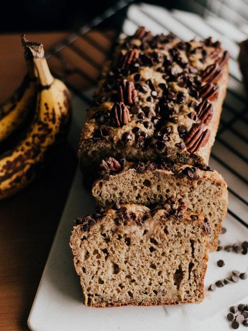 freshly baked banana loaf with nuts and chocolate chips on a board next to an old banana | risking connection | Tempo Therapy and Consulting