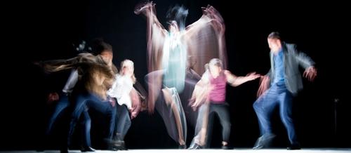 a group of dancers move in a blur against a black background | stress response cycle | Tempo Therapy and Consulting
