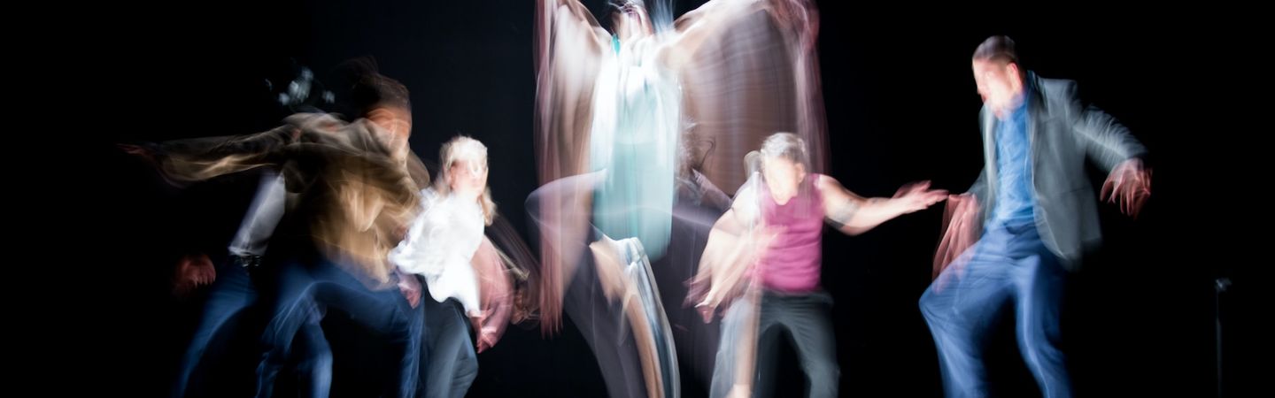 a group of dancers move in a blur against a black background | stress response cycle | Tempo Therapy and Consulting