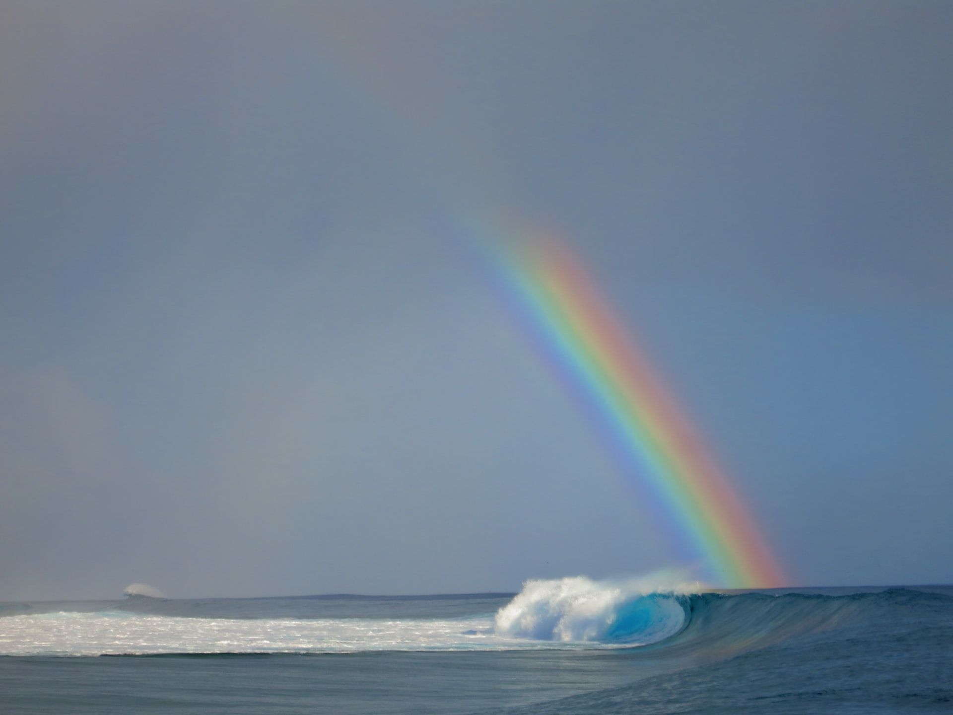rainbow reaches from the sky into a tubular wave in the ocean | hope music connection | Tempo Therapy and Consulting