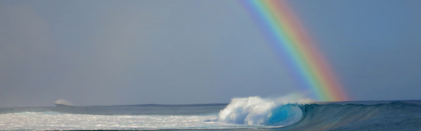 rainbow reaches from the sky into a tubular wave in the ocean | hope music connection | Tempo Therapy and Consulting