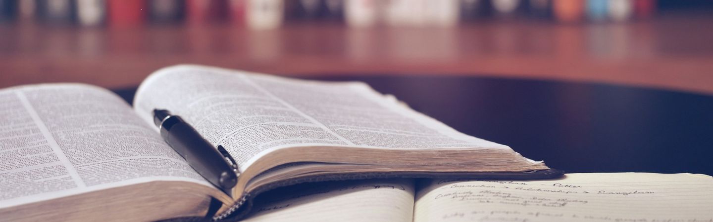 two books lie open on a desk with a shelf in the background. | Tempo Therapy and Consulting | Australian clinical supervisors