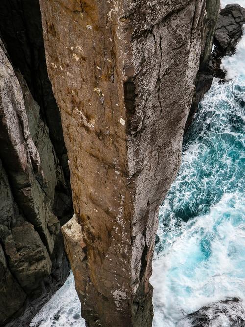 aerial view looking down a pillar of rock as ocean waves crash onto it below | Tempo Therapy and Consulting | hope in healthcare