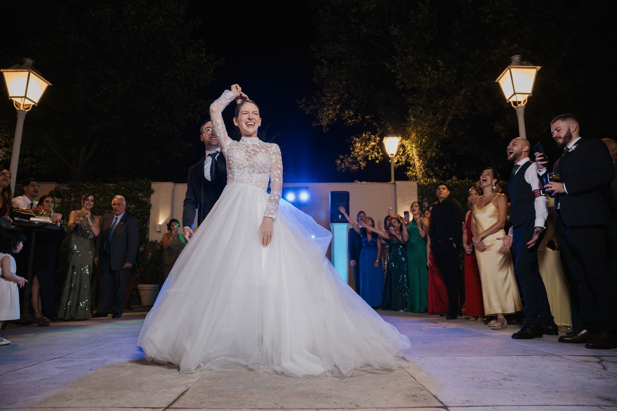 La novia gira bajo el brazo del novio durante el primer baile, con la falda de tul en movimiento