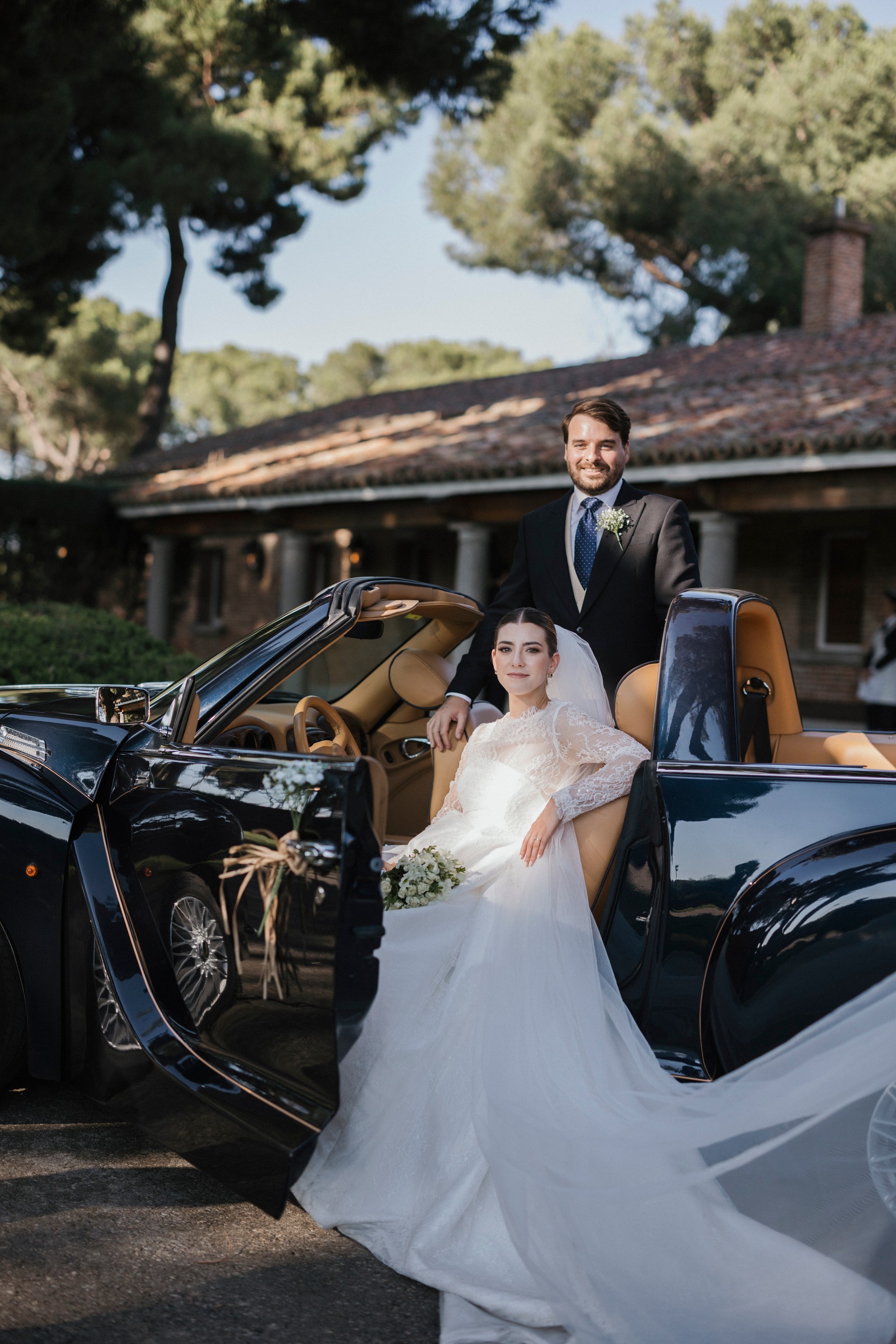 Los novios posan junto al descapotable clásico frente a la finca