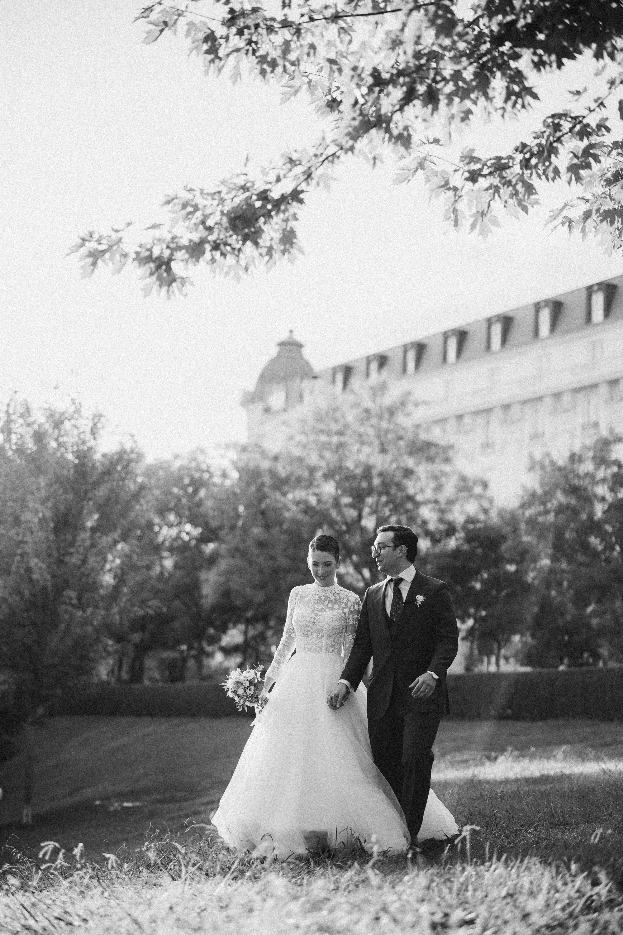 Los novios caminan juntos por el jardín en una imagen en blanco y negro