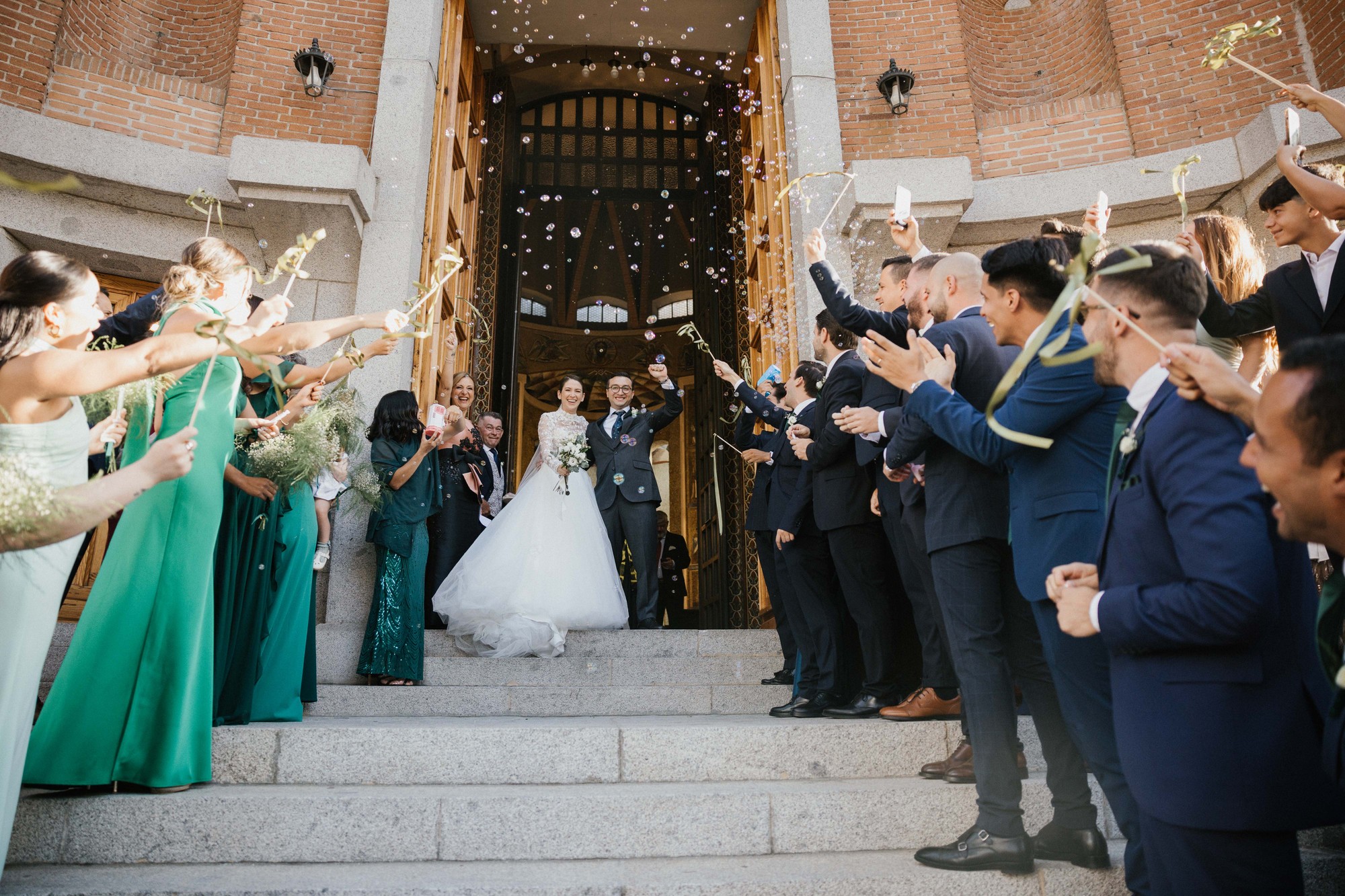 Los recién casados salen de la iglesia bajo una lluvia de pompas de jabón