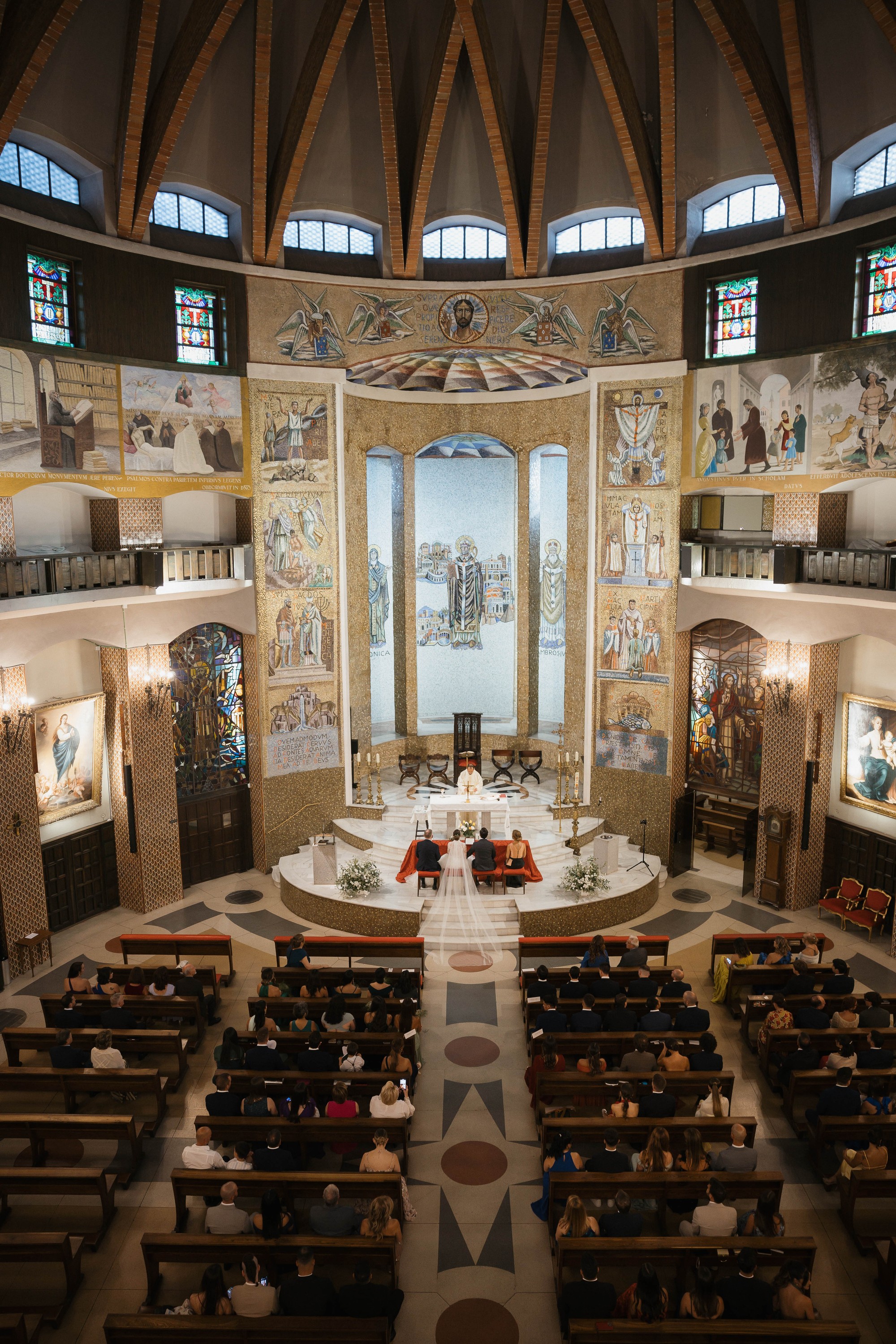 La ceremonia vista desde el coro, con el velo extendido sobre el pasillo y la iglesia llena