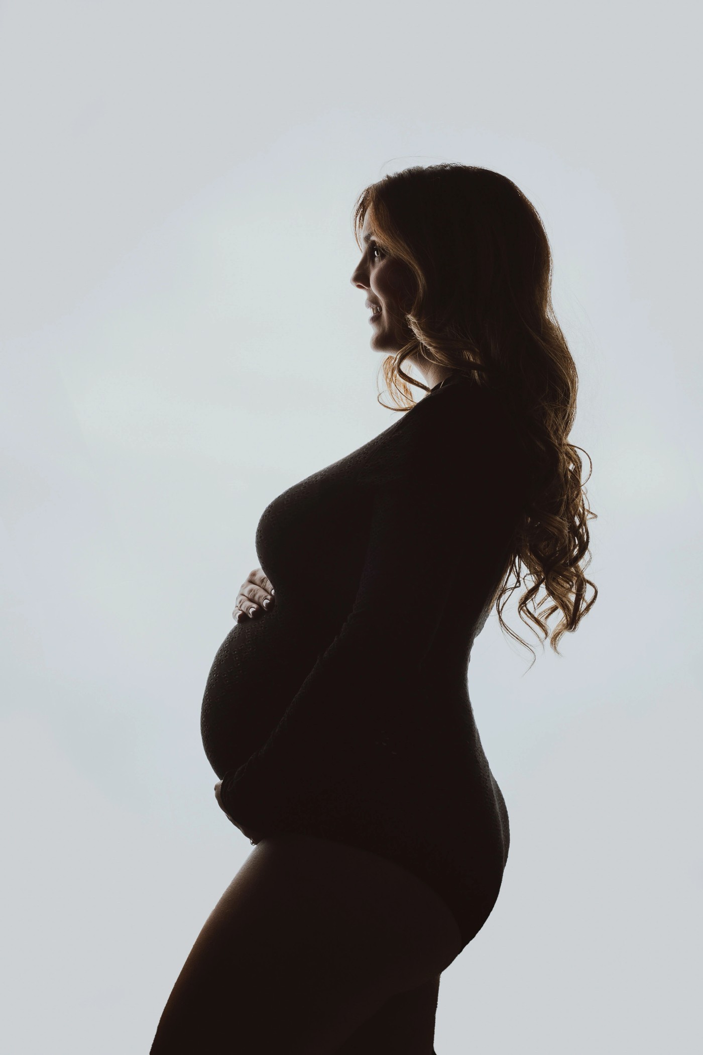 Expecting mother smiling at her son by a fountain