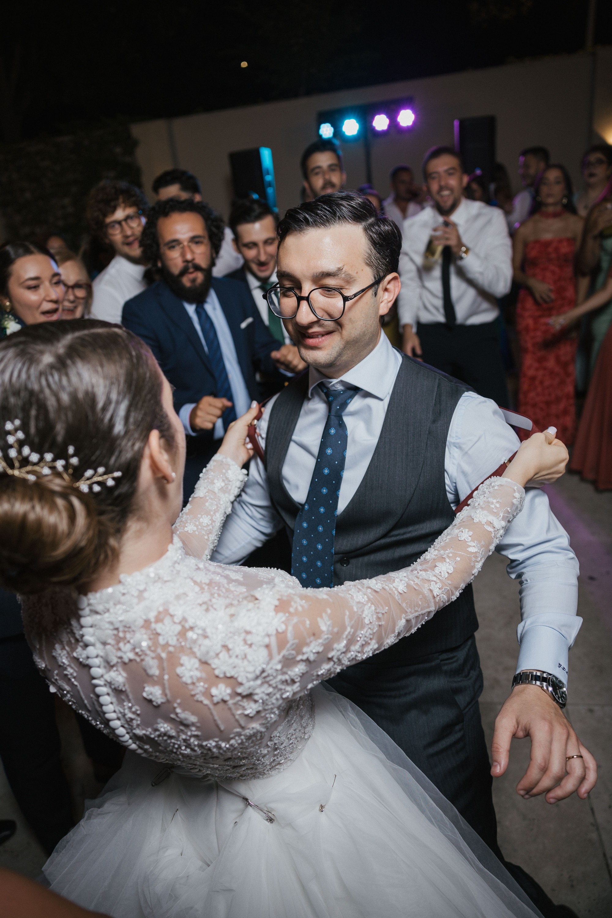 Los novios bailan abrazados rodeados por los invitados en la pista