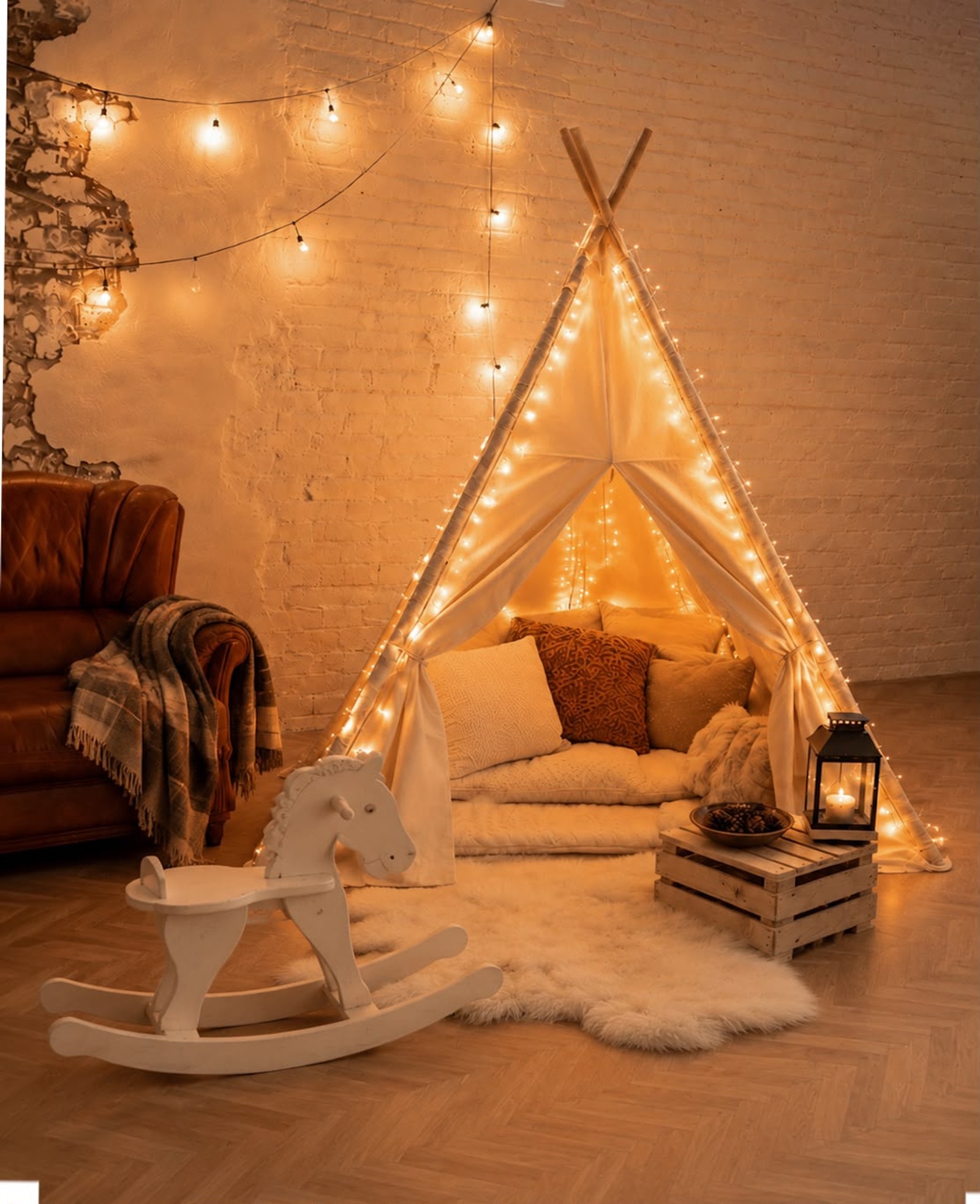 Set La guarida secreta: tipi de tela con cojines y guirnaldas de luces cálidas, alfombra de pelo, caballito balancín blanco y farolillo