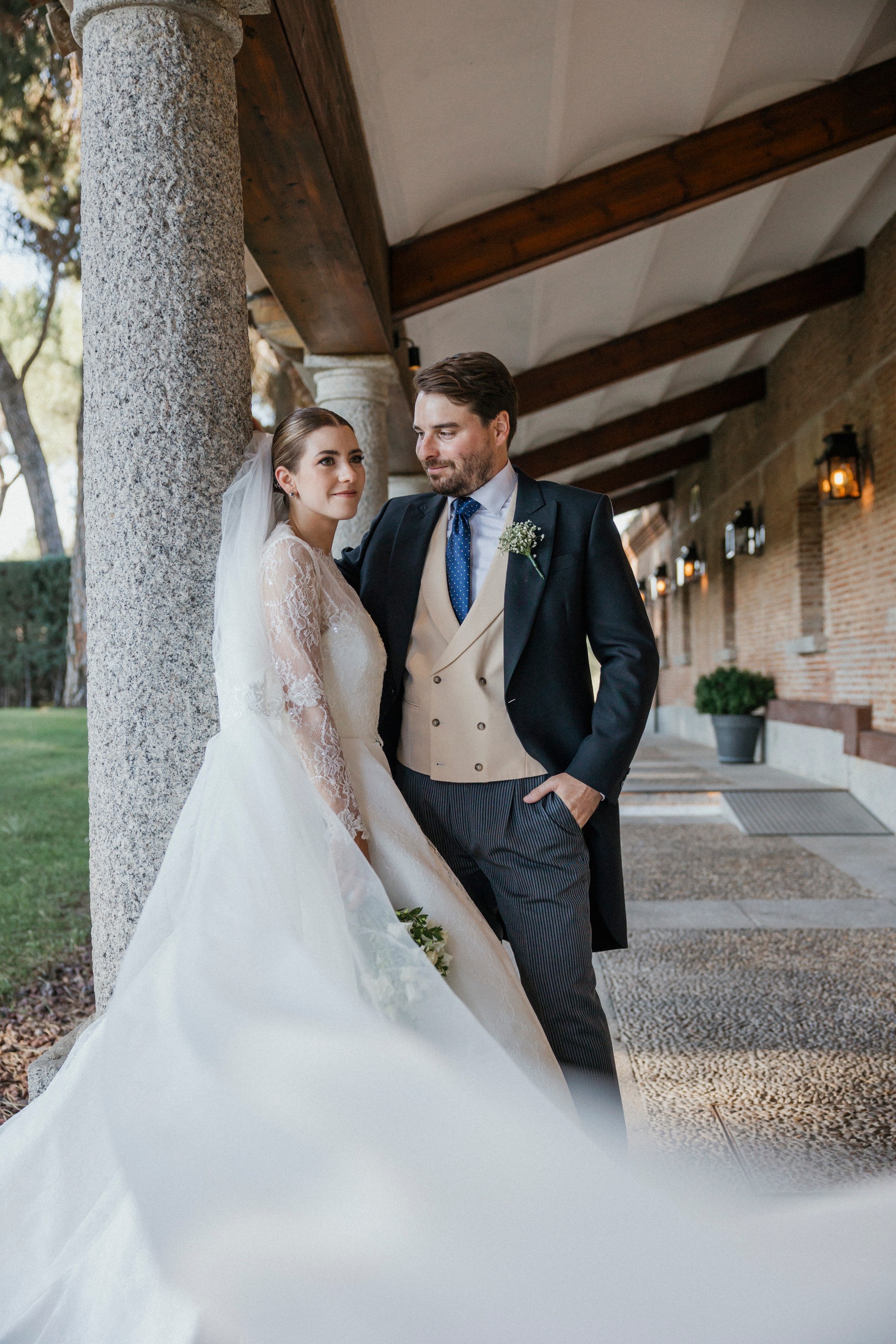 Los novios se apoyan en una columna del porche mientras cae la tarde