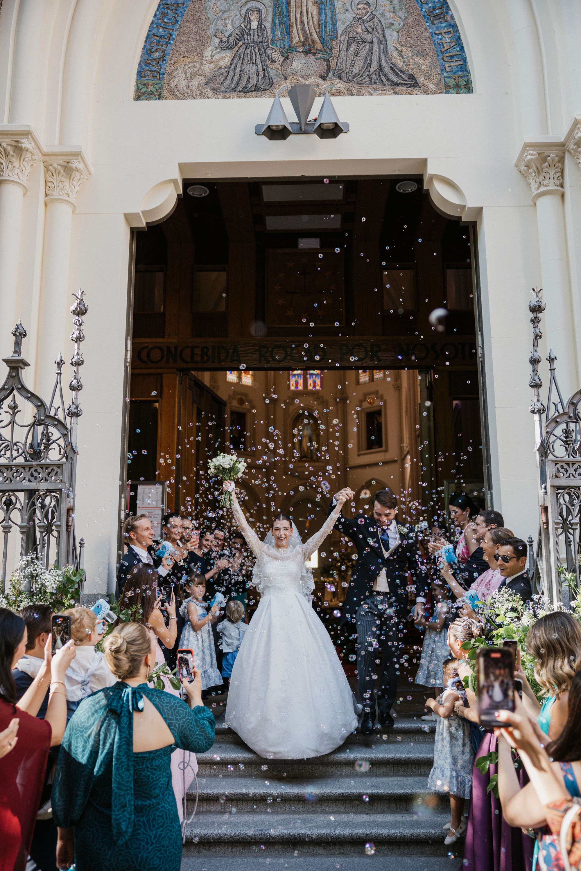 Los novios salen de la basílica entre burbujas y aplausos, con el ramo en alto