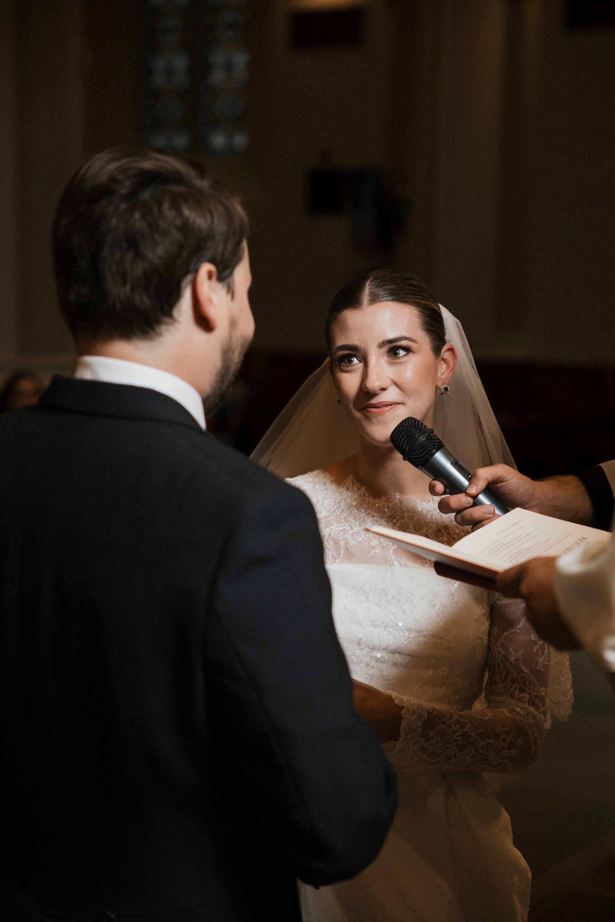 La novia mira al novio mientras pronuncia sus votos ante el micrófono