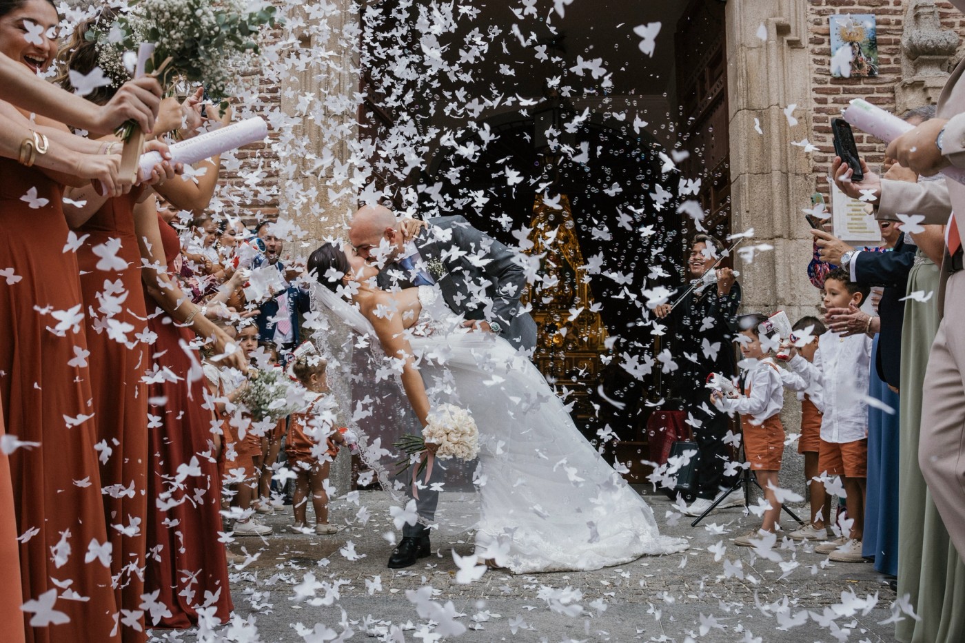 The bride waving from the car as they leave, in black and white