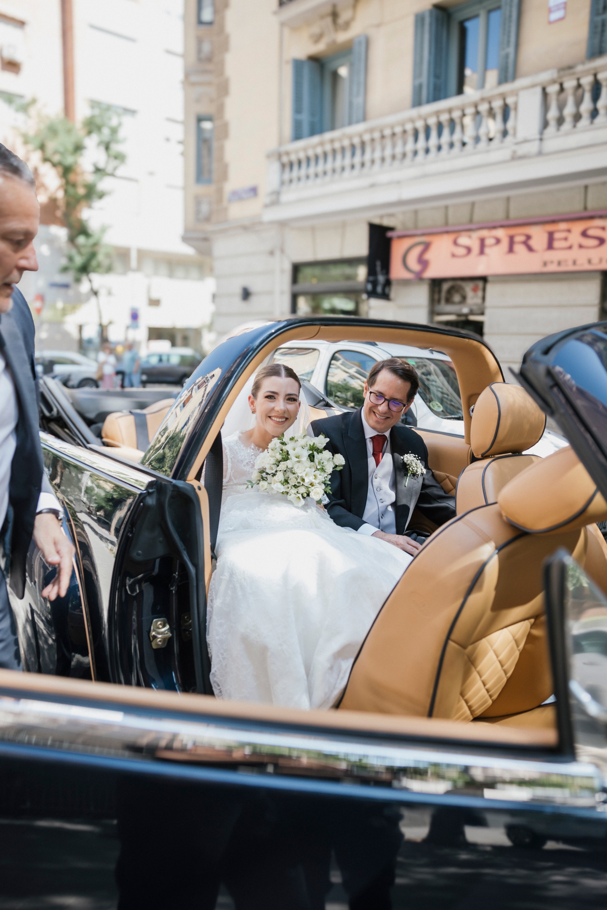 La novia llega a la iglesia en un descapotable clásico con el ramo en las manos